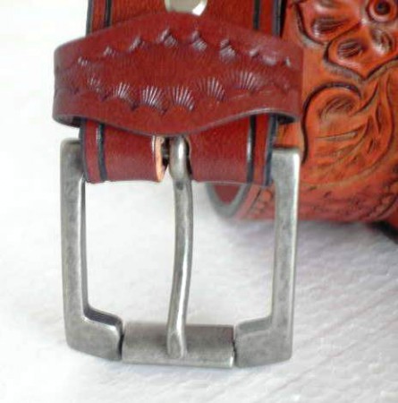 Kožený opasek zdobený basketem a vyřězávaný malým motivem květiny. Třikrát barvený a dvakrát lakovaný.